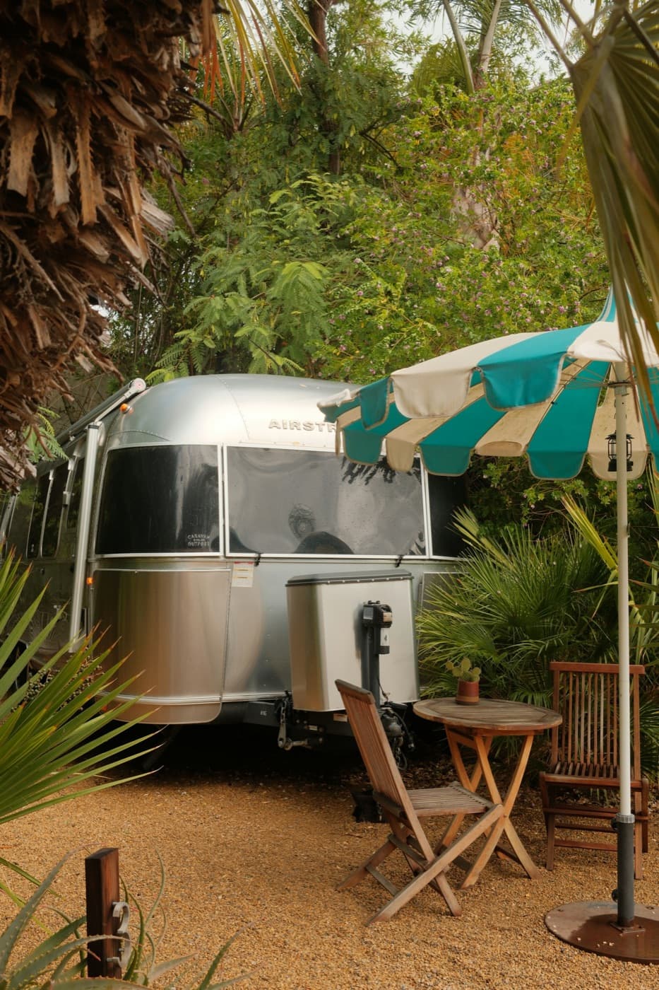 Travel trailer set up beside a shaded patio